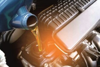 Technician applying automated lubrication to a hydraulic construction machine, ensuring equipment efficiency, safety, and extended service life.