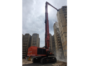Tata Hitachi EX1200V excavator with high-reach demolition attachment operating on high-rise building in Haryana